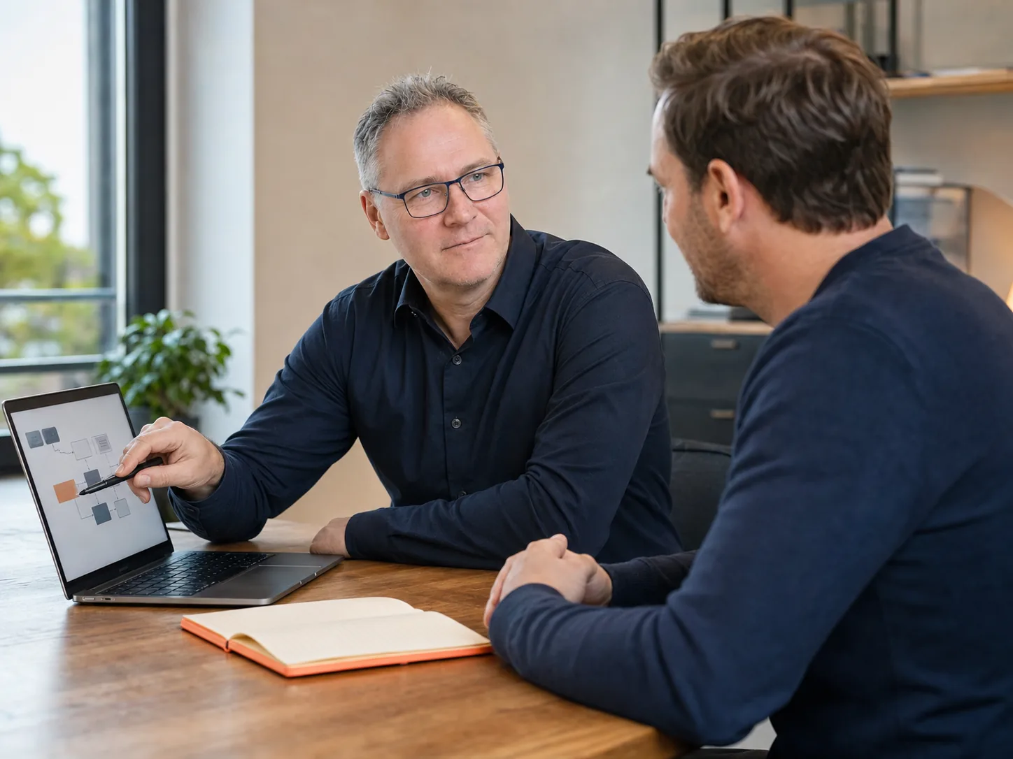 KI-generierte Szene: Sven Frank, KI-Manager (IHK) aus Korschenbroich, erklärt einem Unternehmer einen digitalen Arbeitsablauf